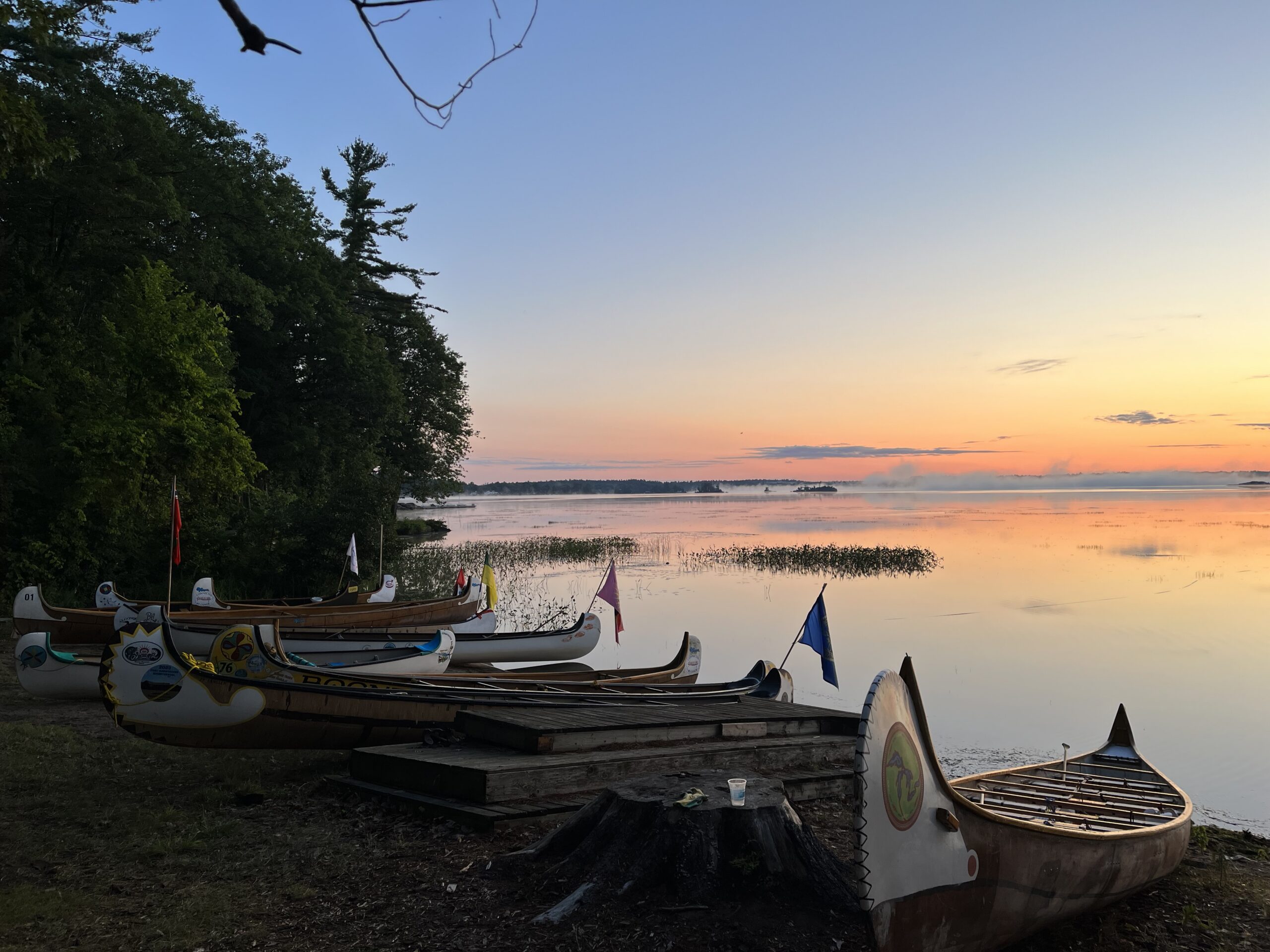CVBS crew paddling a voyageur canoe through a narrow tree-lined waterway at Sparrow Lake, Ontario